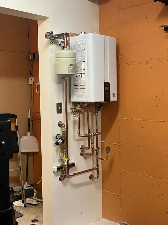 Plumbing technician inspecting water heater connections in Solon